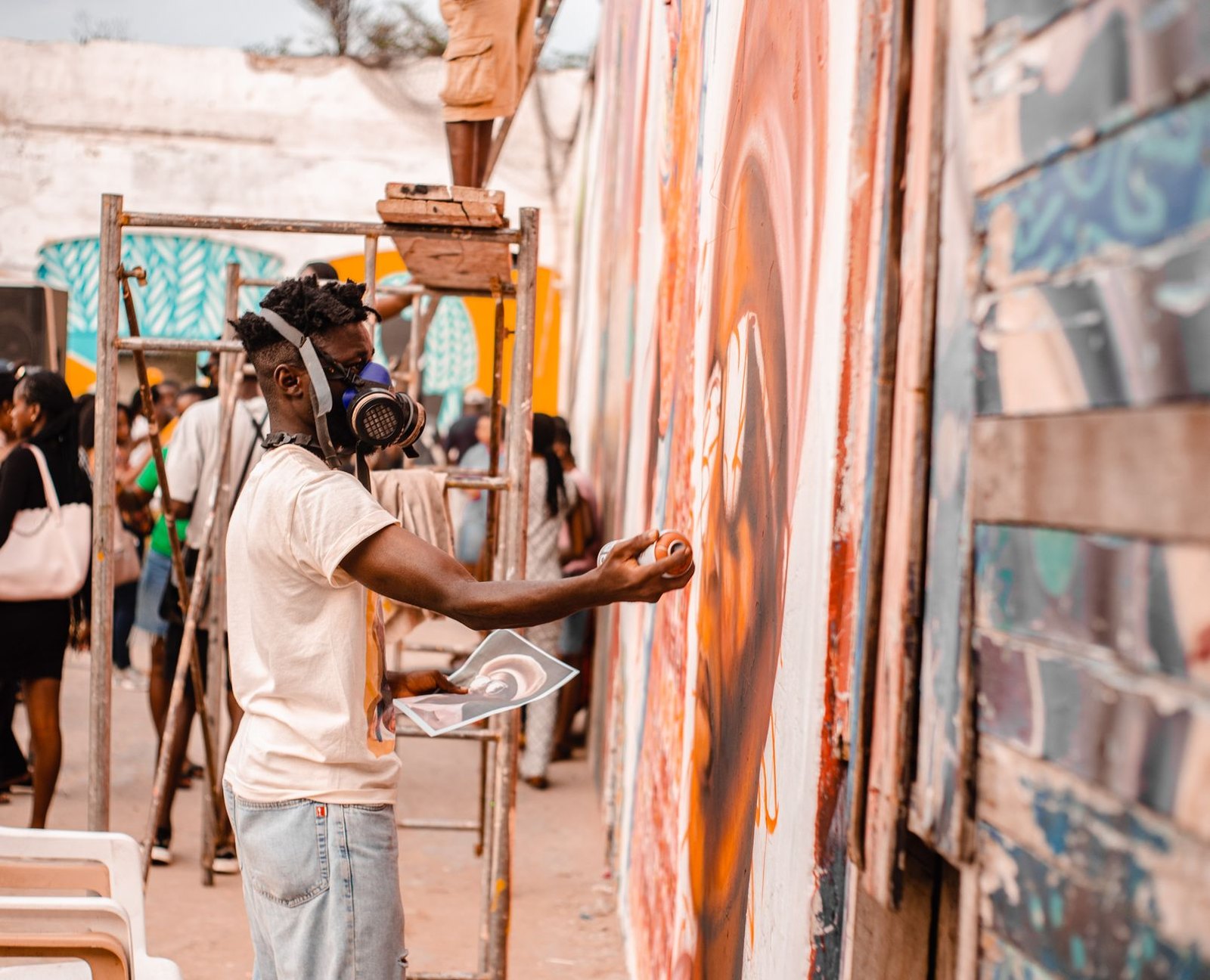 Children painting on large mural wall at community event