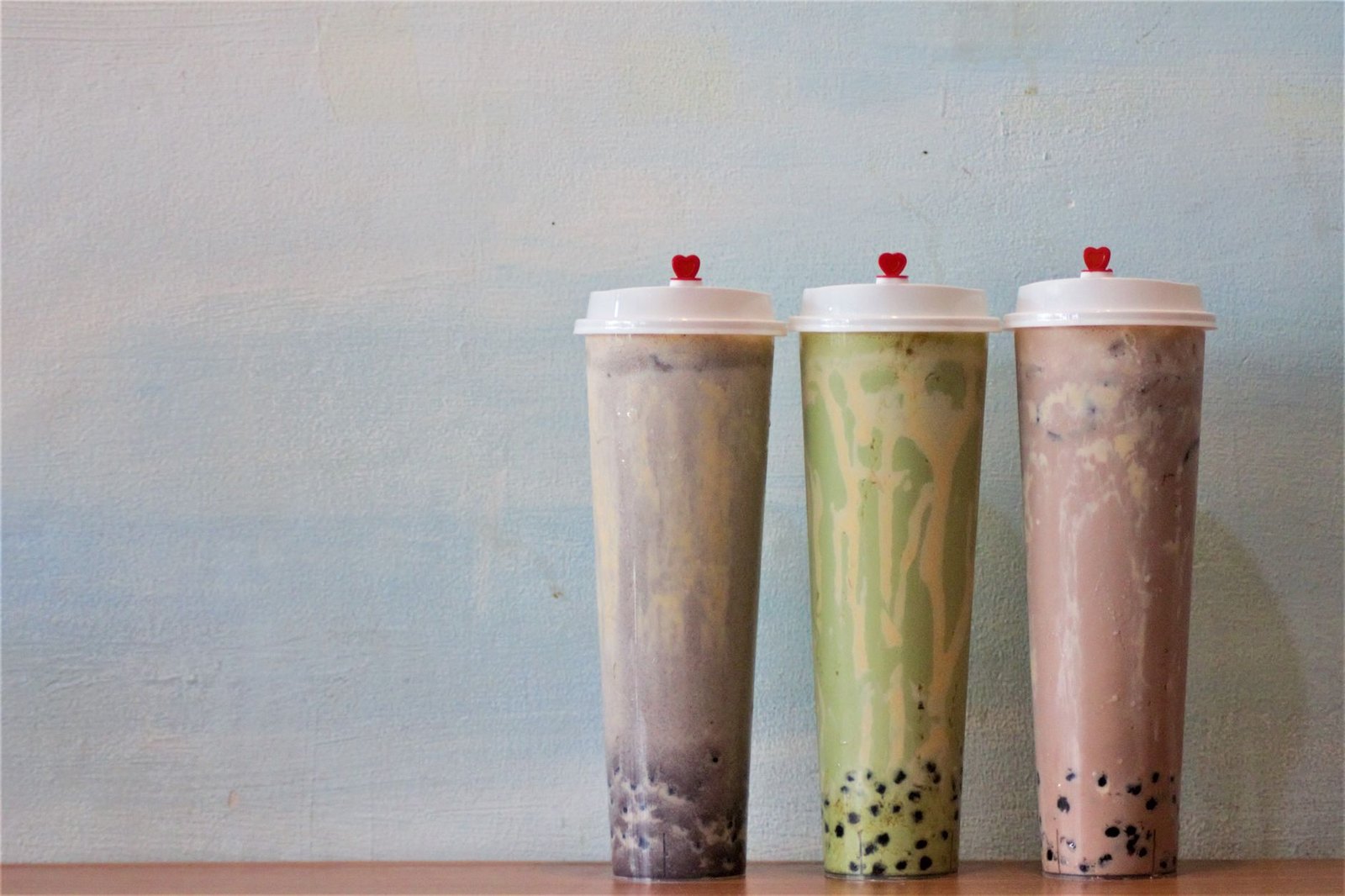 Mango smoothie and boba milk tea drinks in clear cups