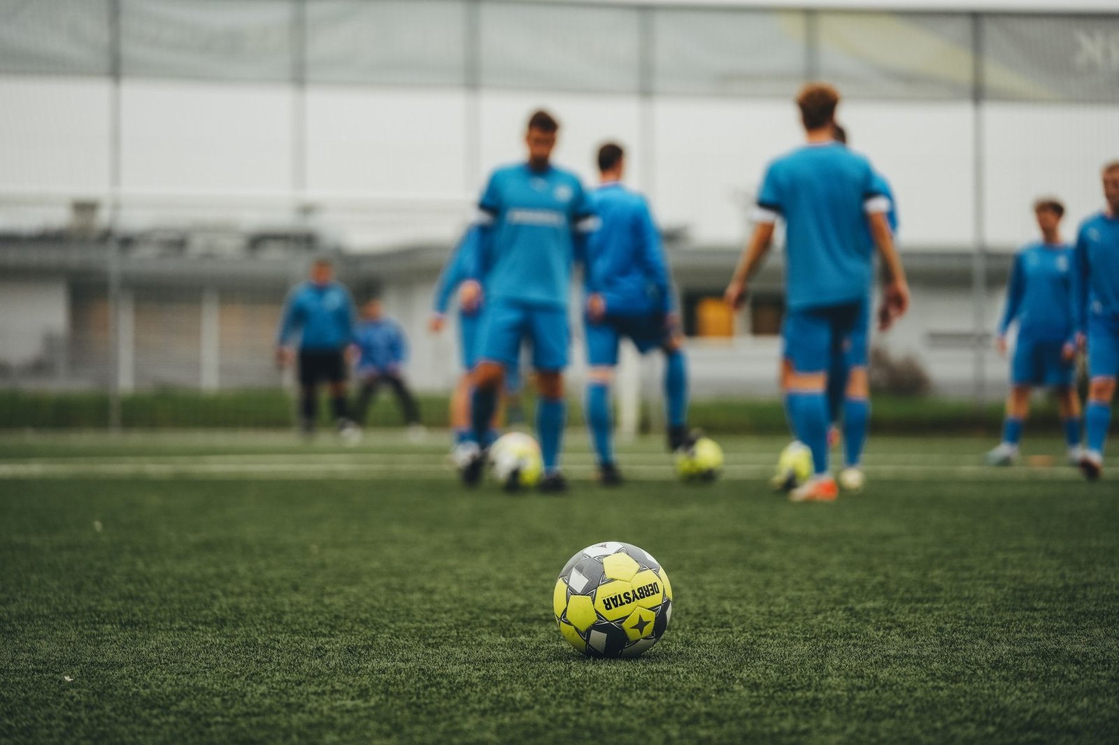 Kids playing soccer on a synthetic turf field during a fall season game