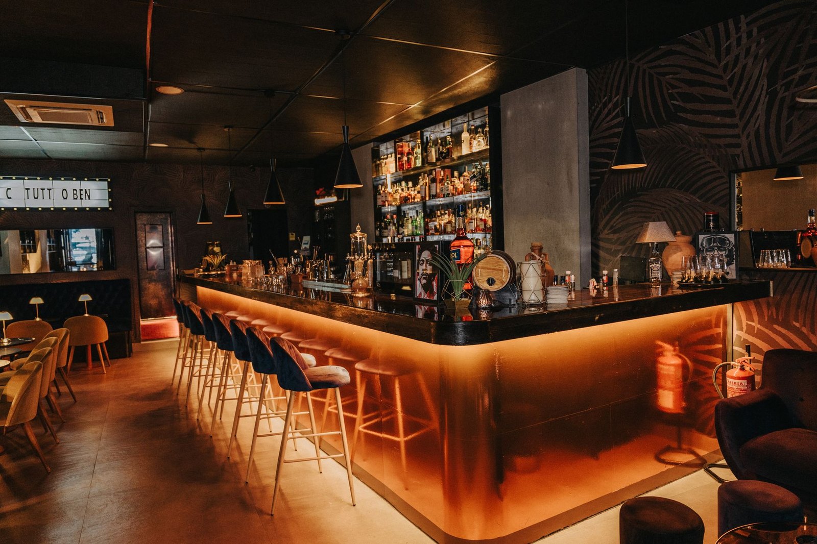 Warm-lit bar and lounge seating, the style Den10 suggests