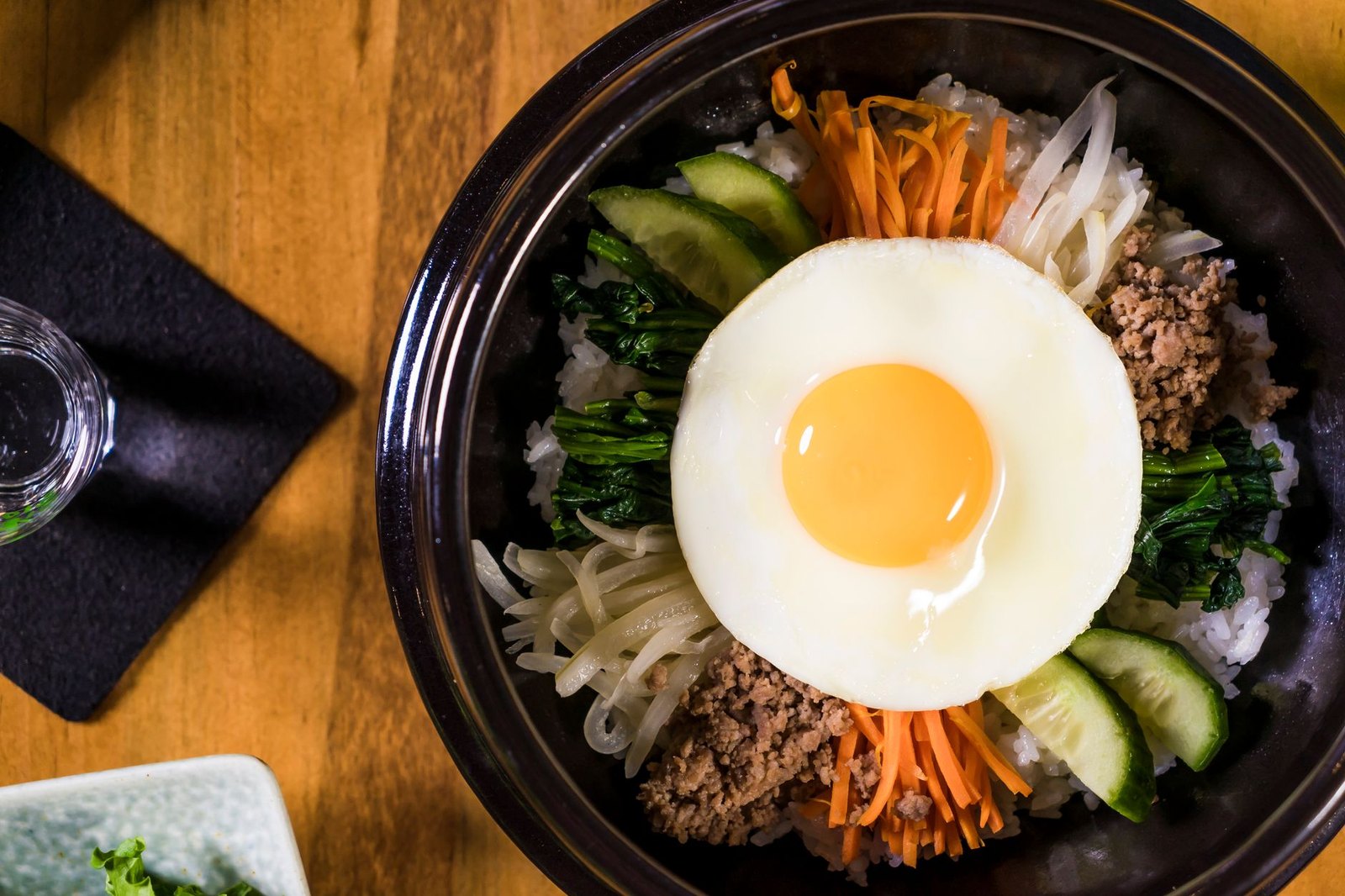 Bibimbap served in a hot stone dolsot bowl with vegetables and egg