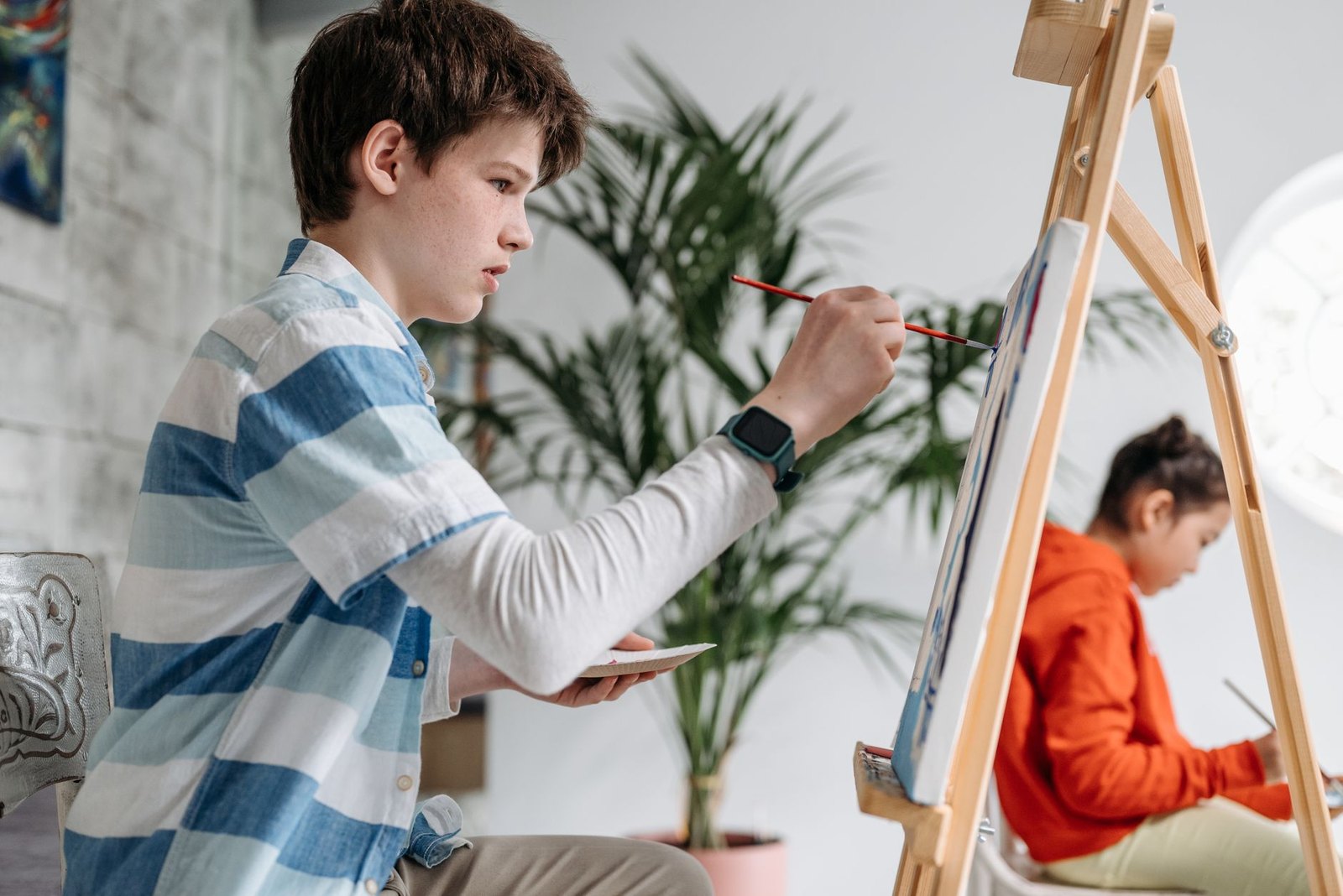 Young students working on paintings in an elementary school art class