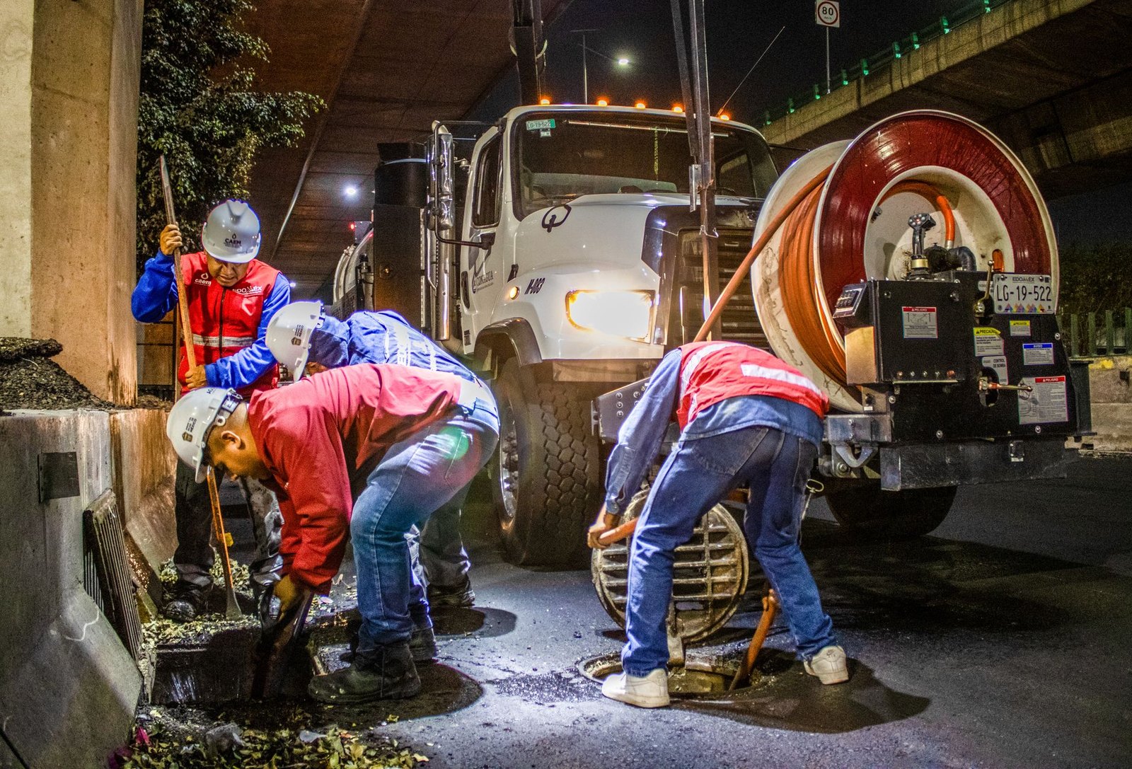 Construction crew performing cured-in-place pipe lining rehabilitation on a residential sewer line
