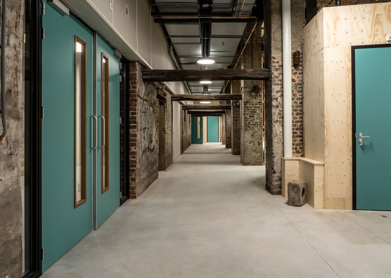 Interior school hallway mid-renovation with construction materials and temporary barriers