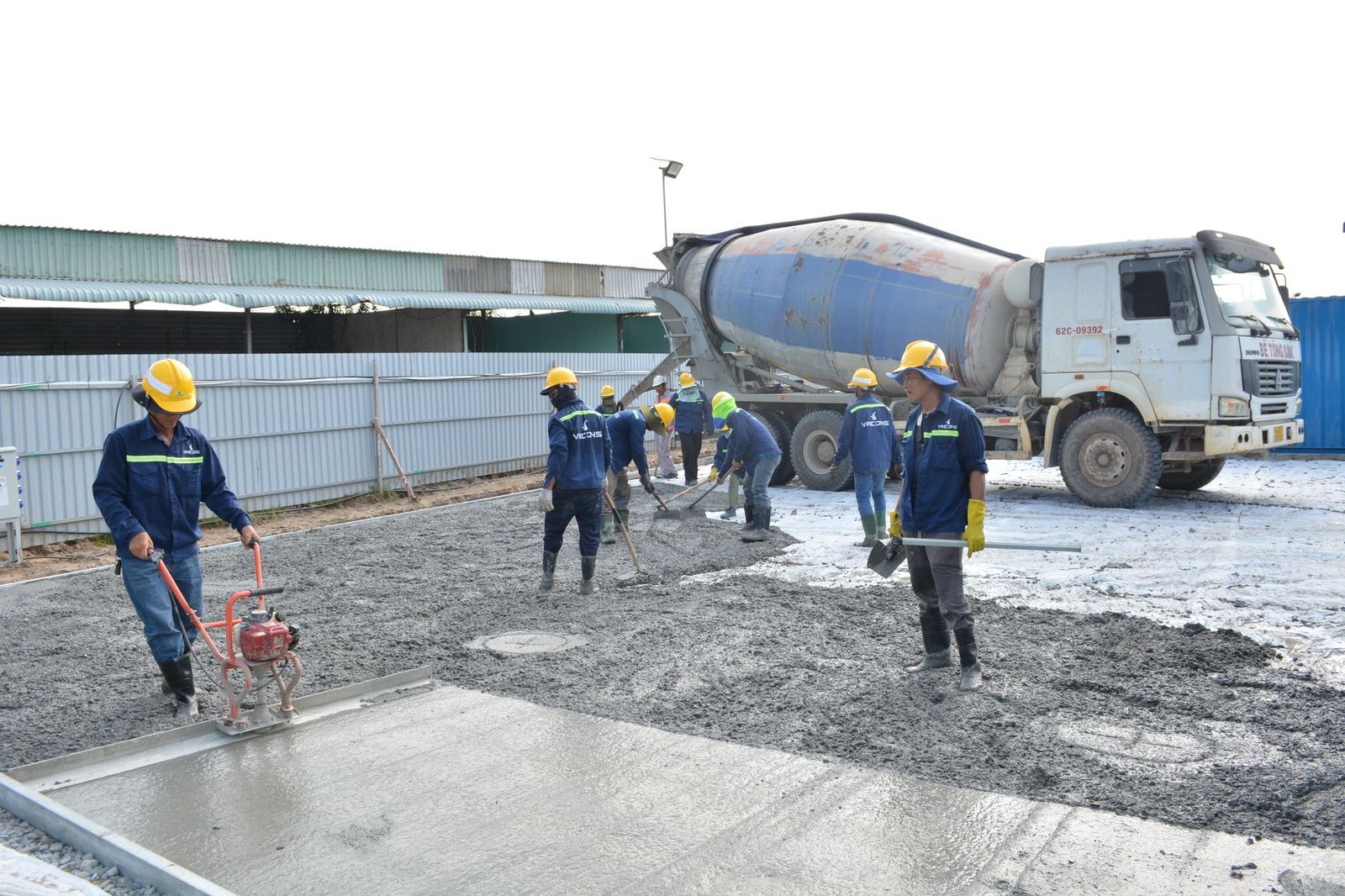 Construction workers replacing concrete road panels on a residential arterial road