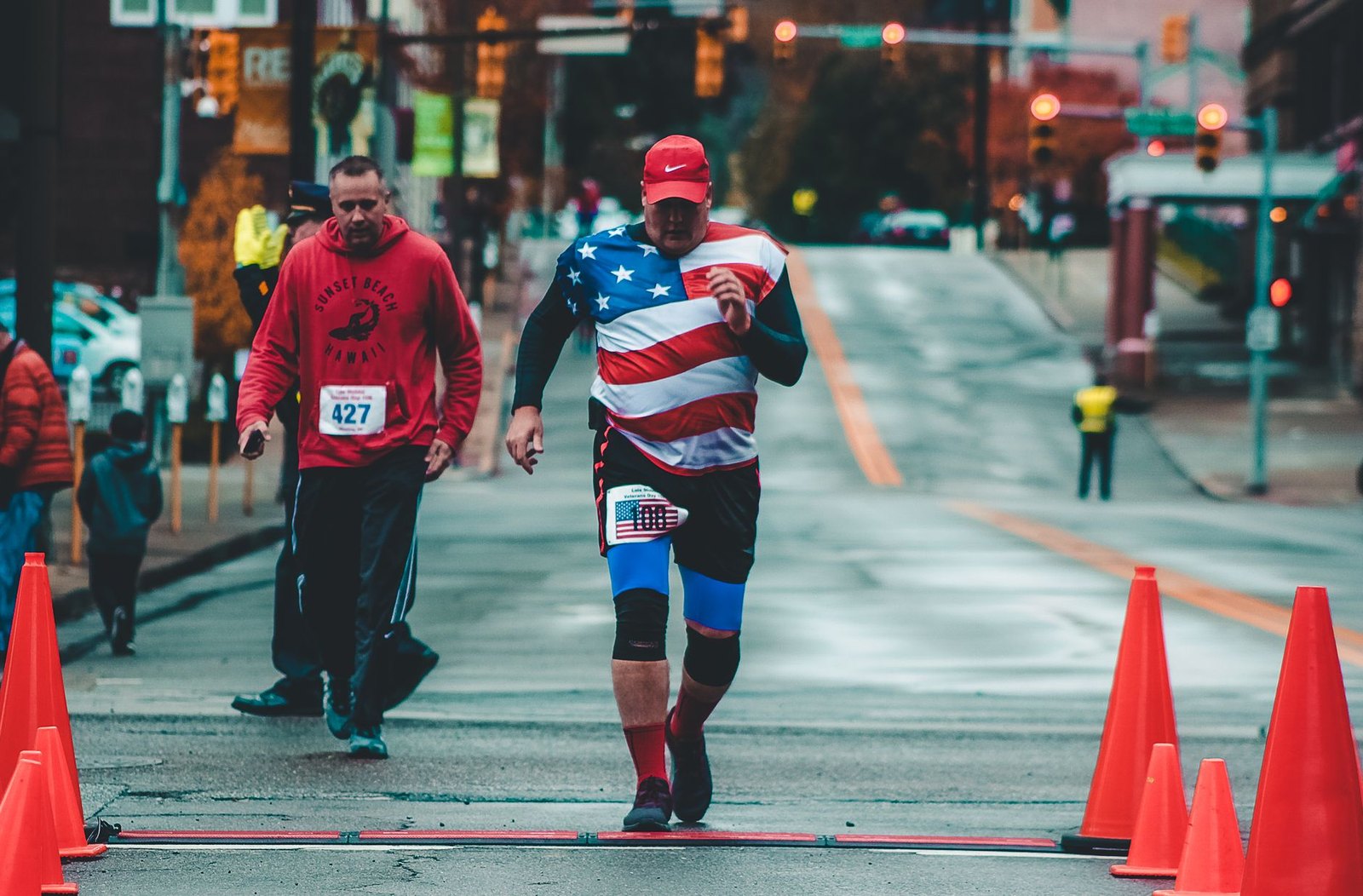 A runner carries an American flag along a Flower Mound street during the Veterans Day Relay Run