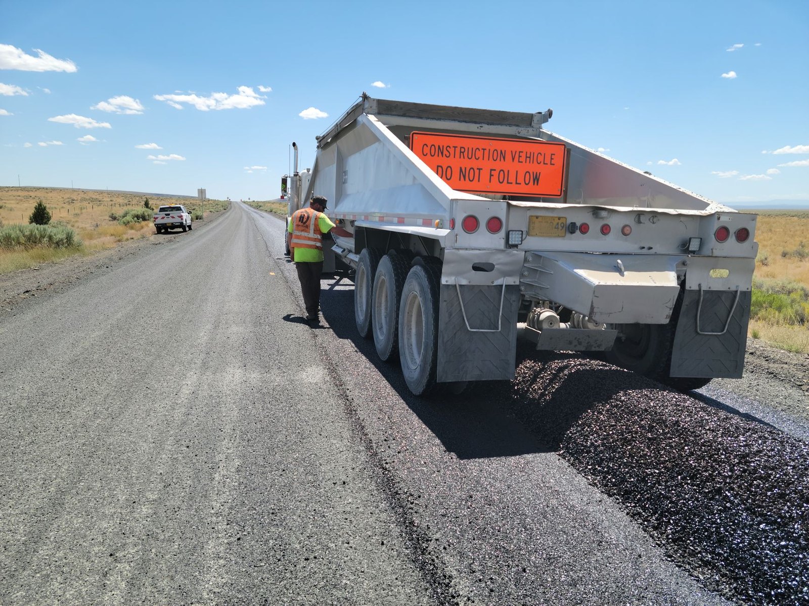 Construction crew working on intersection lane expansion with paving equipment
