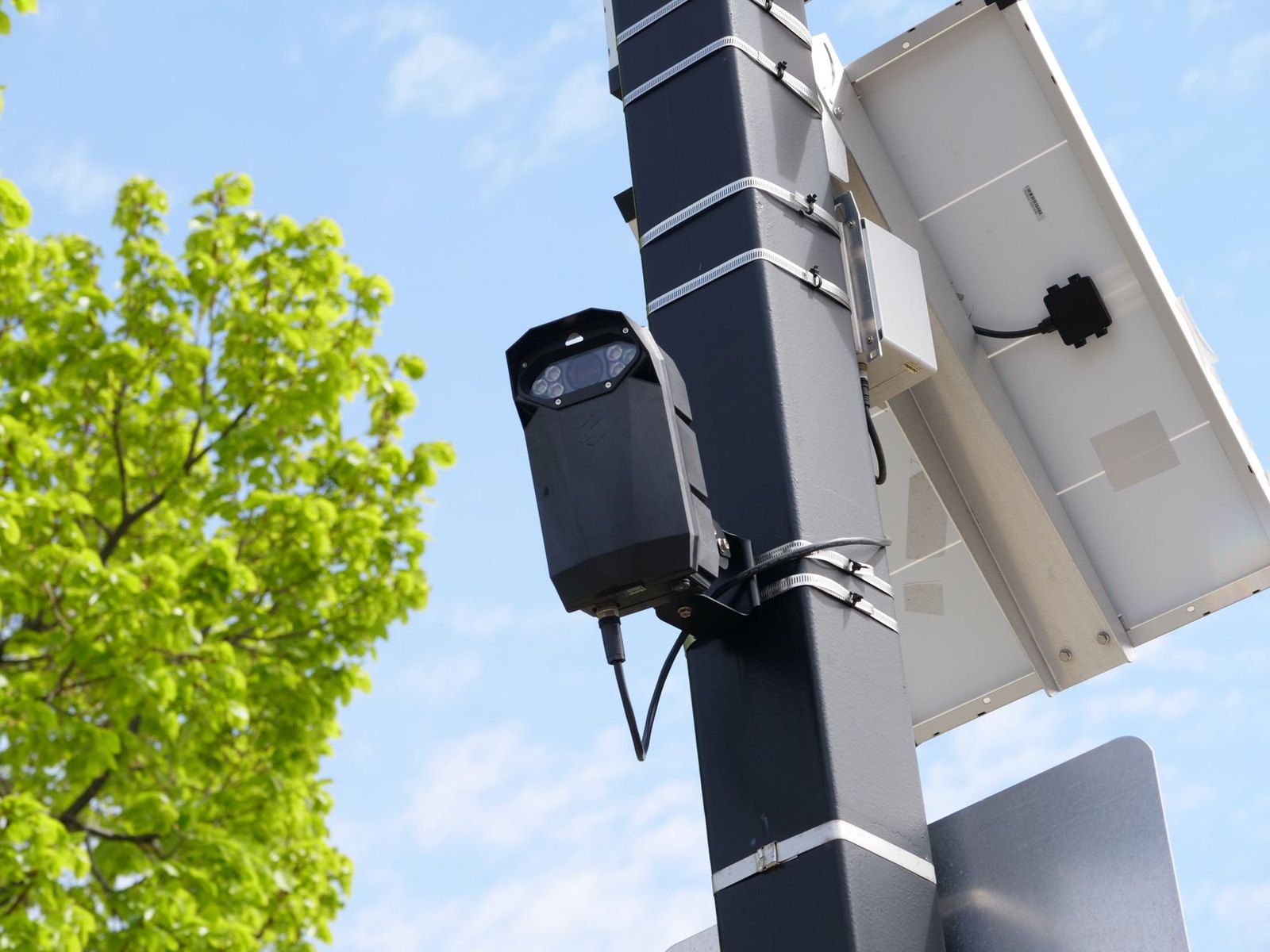Flock automated license plate reader camera mounted on a roadside pole