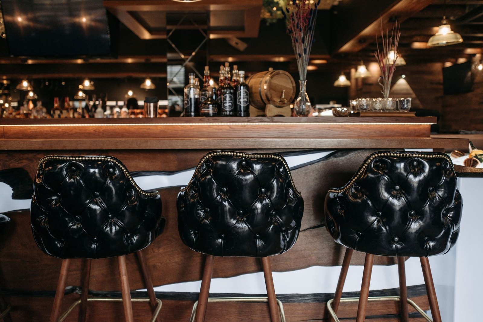 Warm leather booths and a wraparound bar inside an upscale-casual coastal restaurant, the style coming to the Shops at Highland Village