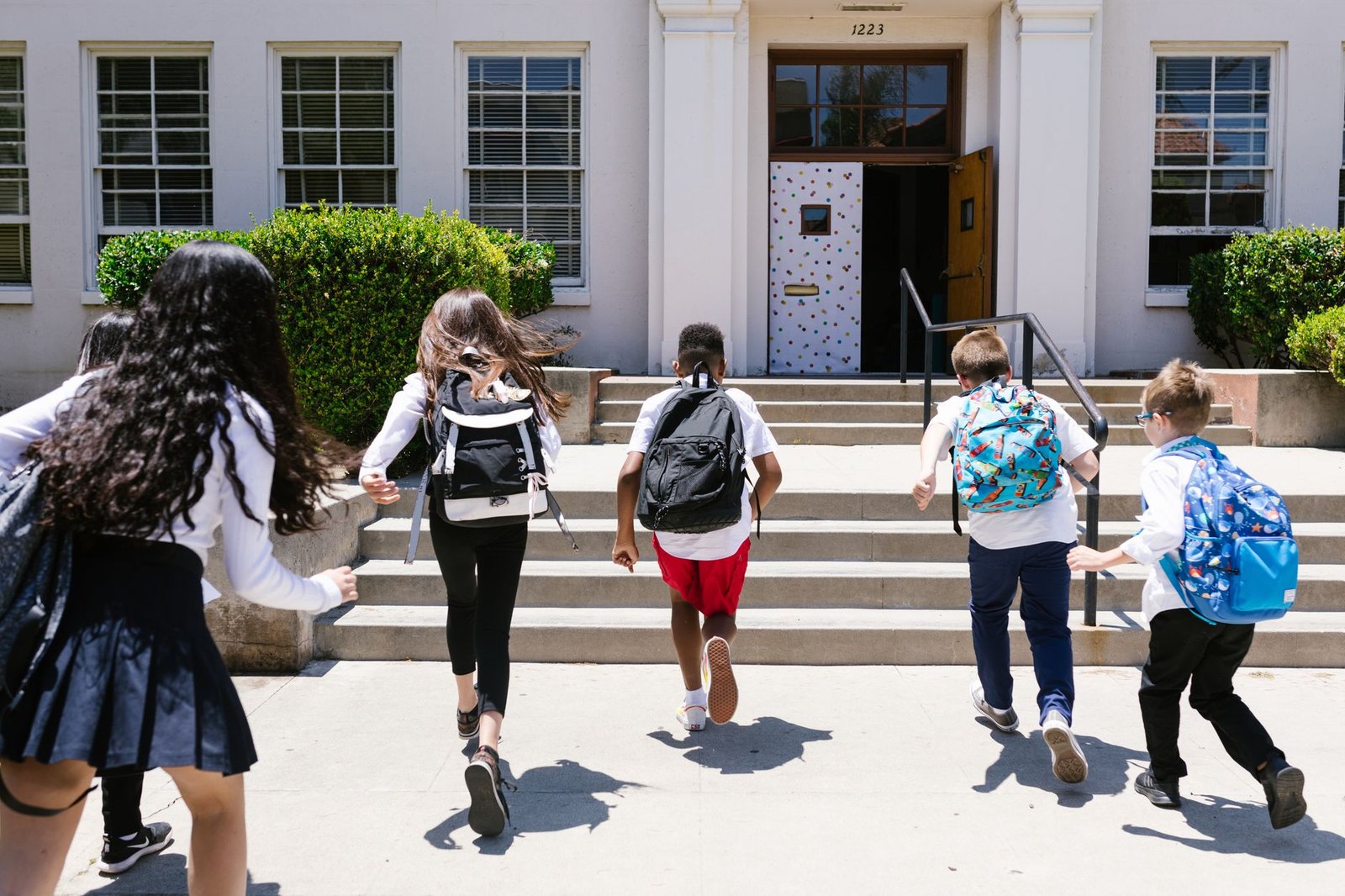 Students with backpacks walking into school on the first day