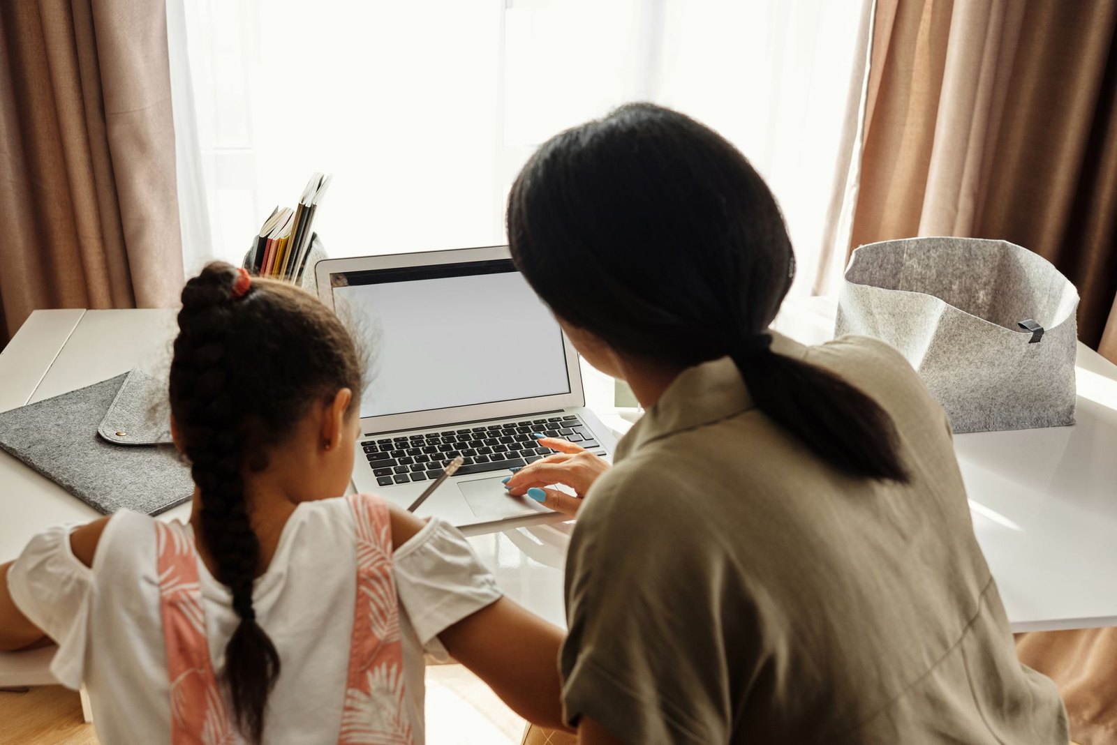 Parent sitting at laptop completing back-to-school registration forms