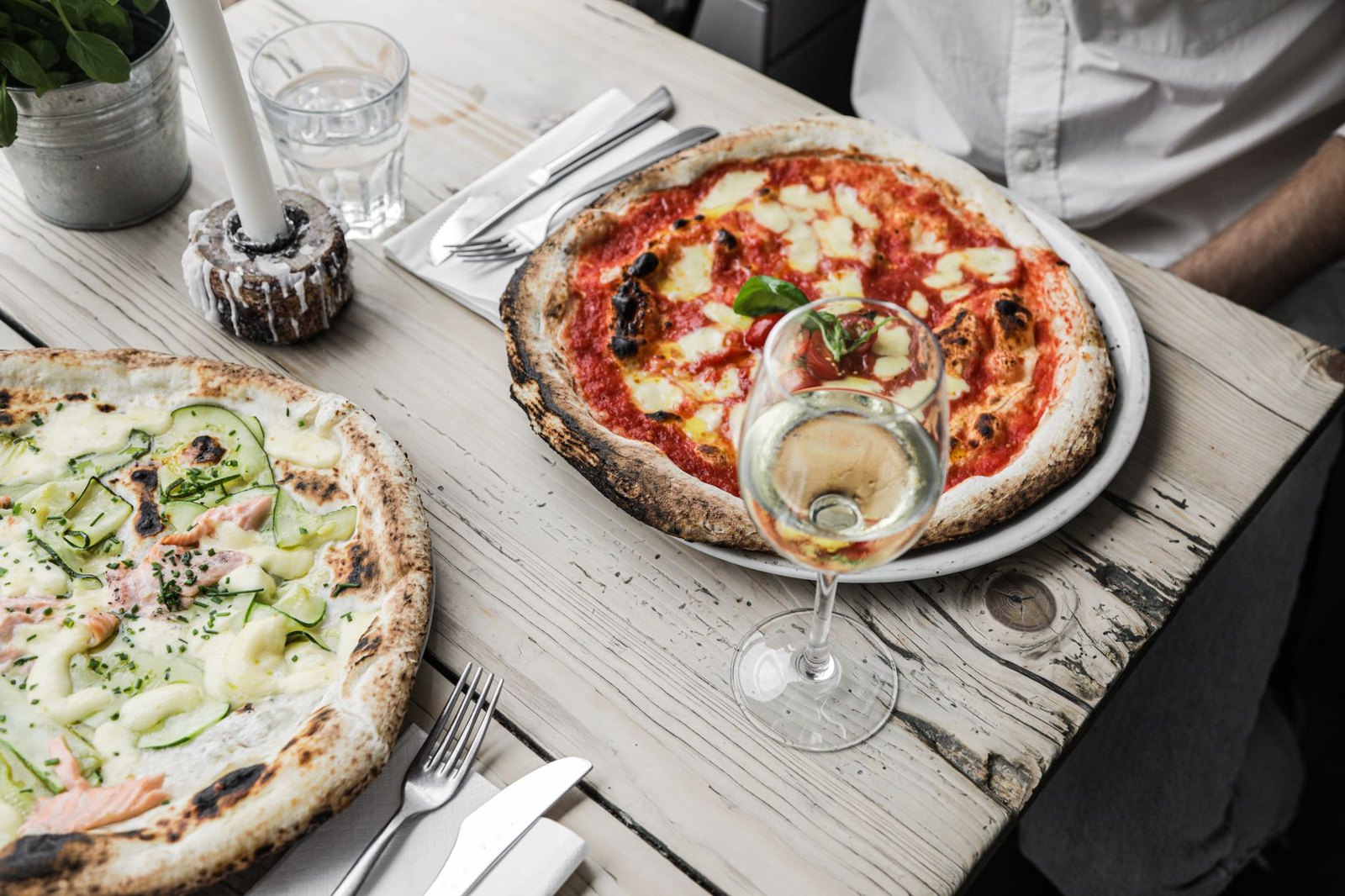 Wood-fired pizza emerging from a pizza oven at an Italian trattoria