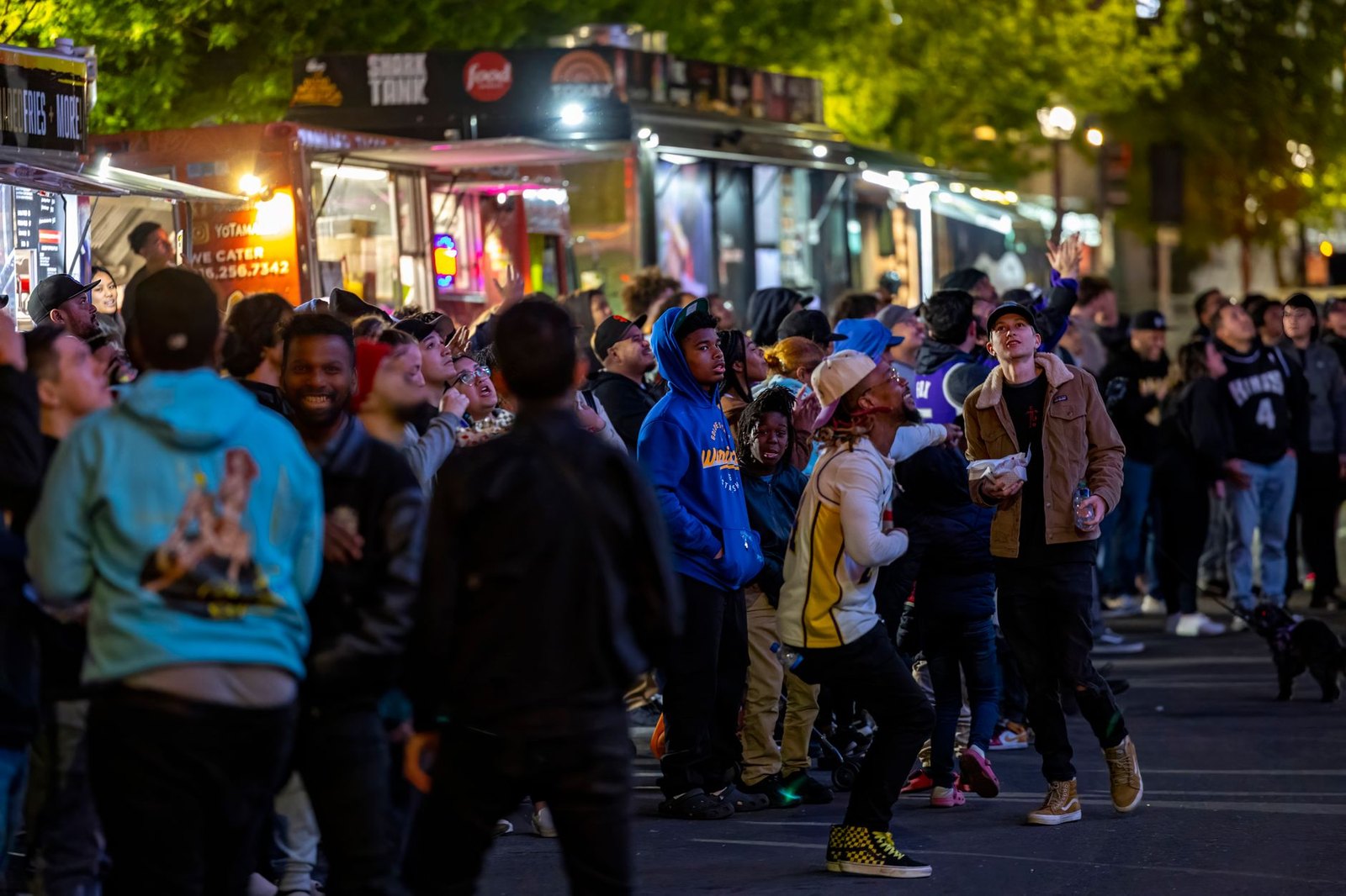 Neighbors gathered at outdoor block party on residential street evening