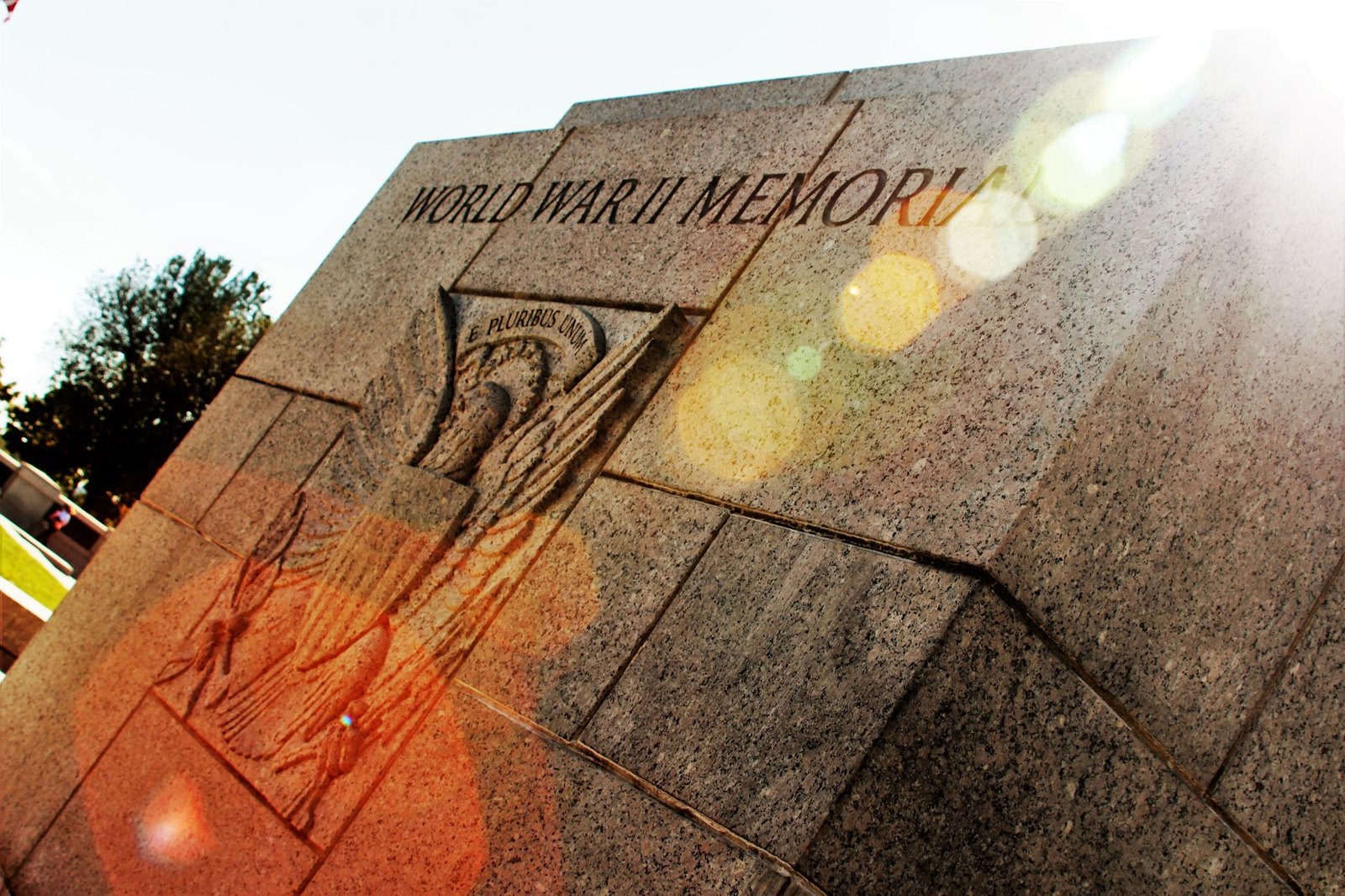 Outdoor veterans memorial plaza with commemorative monuments in a park setting