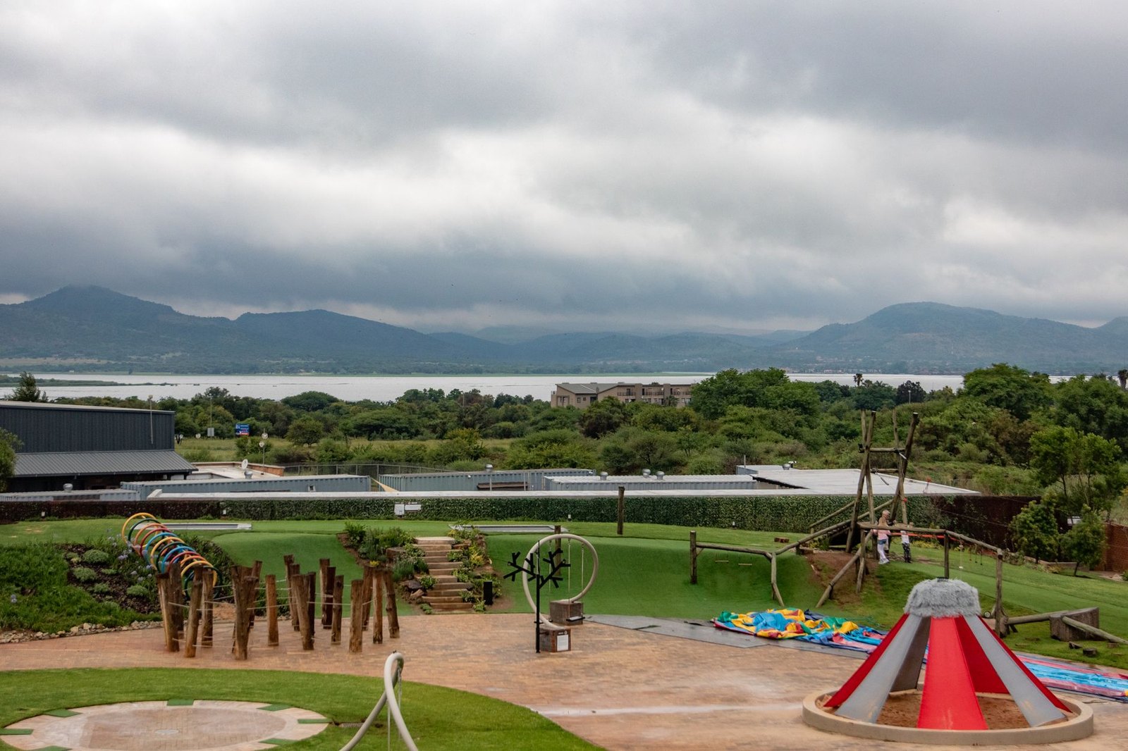 Berm-style playground with synthetic grass hills, similar to the design planned for Post Oak Park