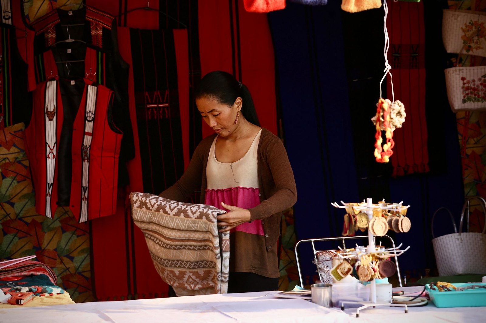 A small business vendor arranging merchandise in a retail booth space