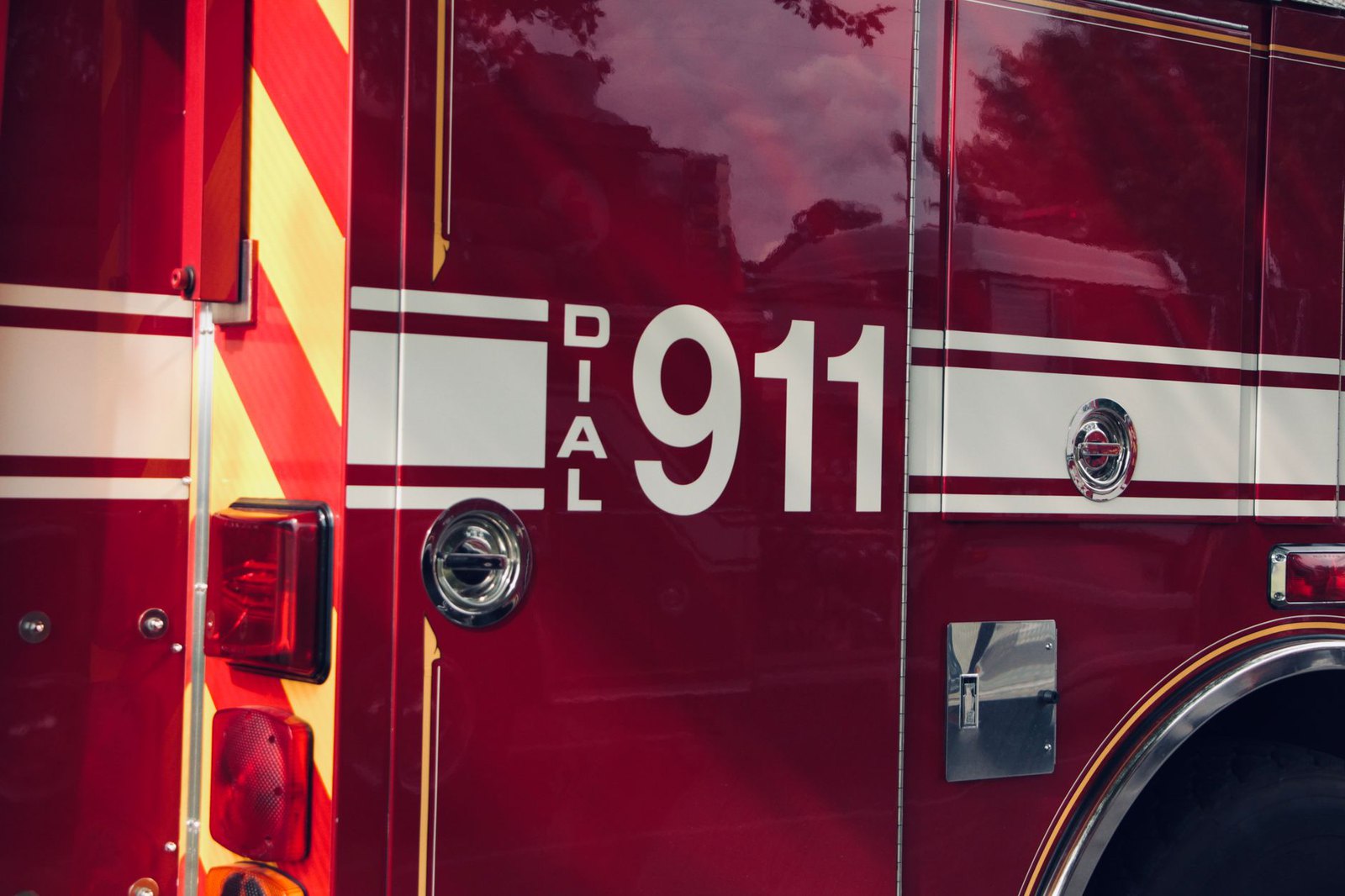 Young child standing beside a fire truck, looking up at the cab
