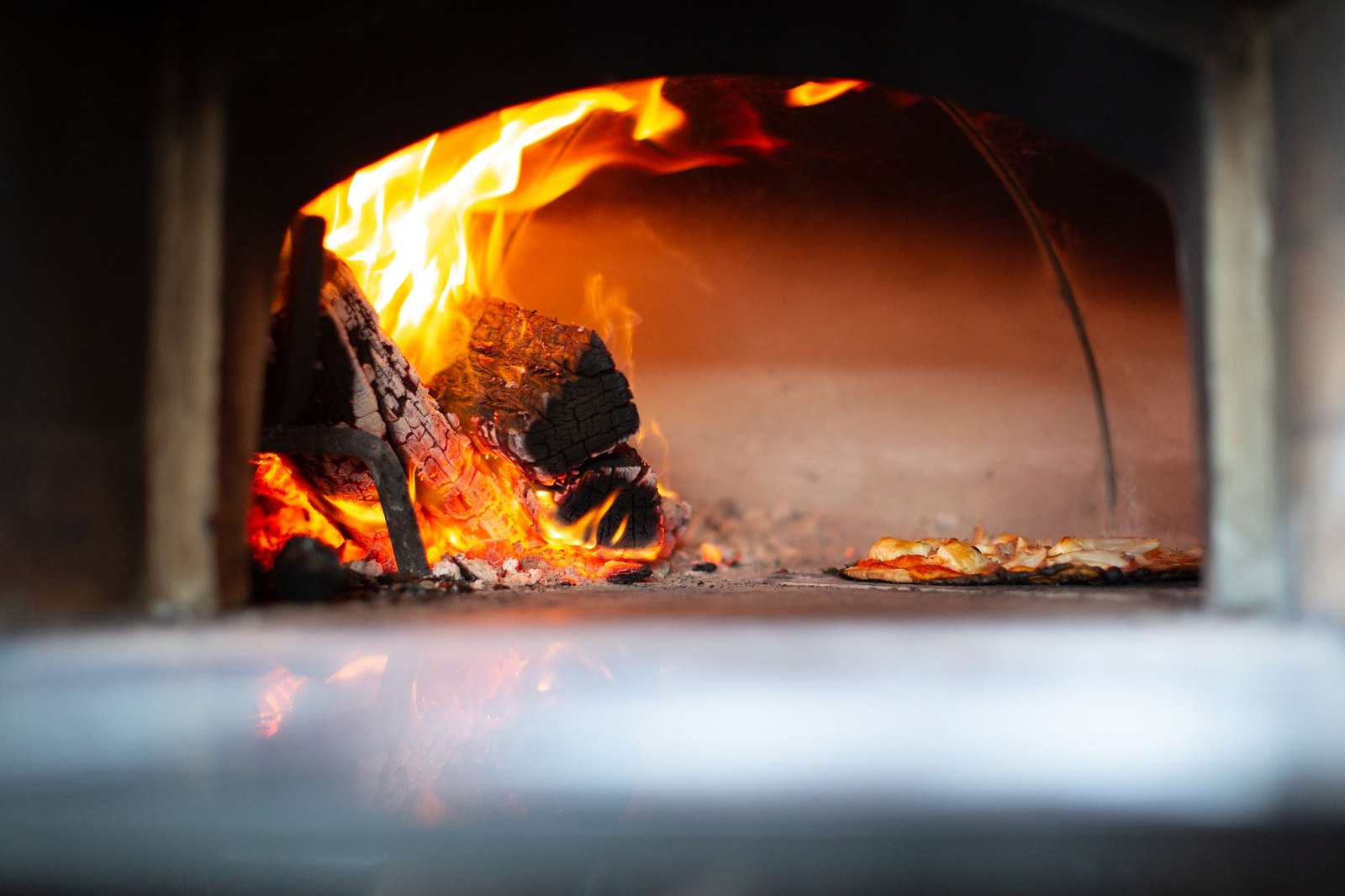 Wood-fired pizza oven with flames, the style Vivo Pizzeria will bring to Lakeside